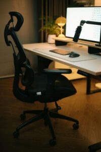 Profesional sentado en silla ergonómica con reposacabezas ajustable en oficina.