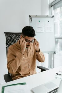 Hombre ajustando la altura de una silla ergonómica en su escritorio.
